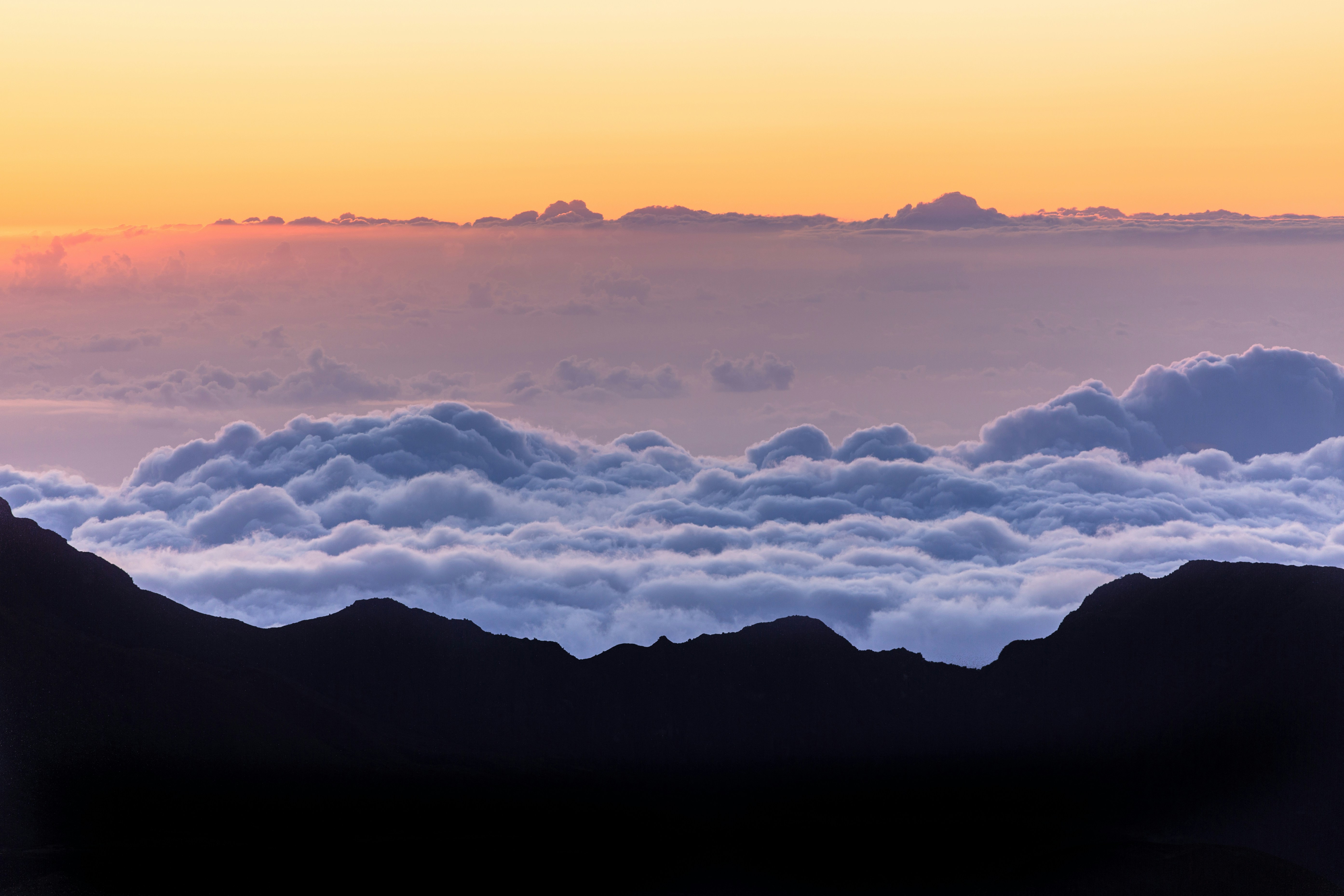 Silhouetted mountains with clouds at sunset.